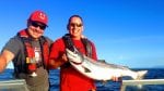 Two successful fishermen with a salmon from their fishing charter