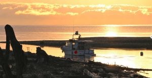 Boat and beach in sunset during shoulder season at Pacific Playgrounds Vancouver Island Resort